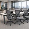Escritório corporativo com estações de trabalho ergonômicas e área de apoio ao fundo